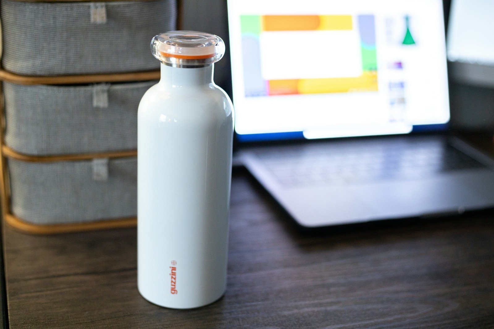 turned-on gray laptop computer near white bottle