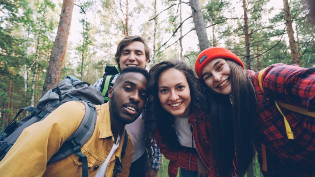 Four friends taking a selfie in a forest.